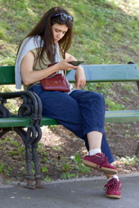 Girl watching her smarphone on a bench